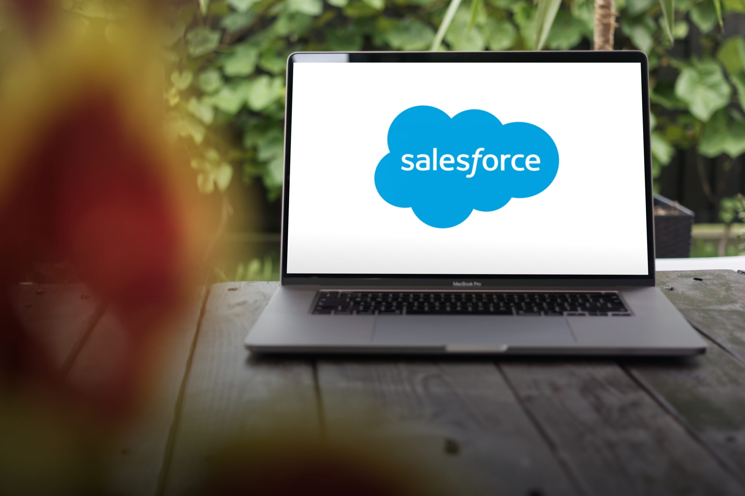 a laptop sitting on a table with the Salesforce logo on the screen